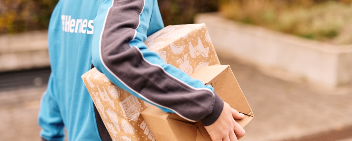 HERMES-Mitarbeiterin trägt Weihnachtspakete Hermes stellt sich zum Weihnachtsgeschäft 2021 erneut auf Rekord-Paketmengen ein. (Foto: Hermes)
