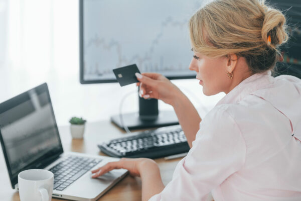 Using credit card for payment. Female stock broker in formal wear is working in the office